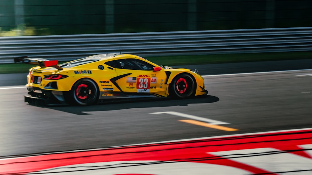 a yellow sports car driving down a race track