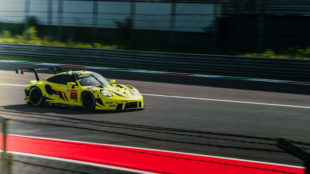 a yellow race car driving down a race track