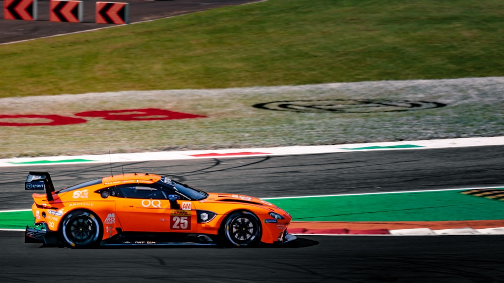 an orange sports car driving on a race track