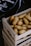 Close-up of fresh, vibrant potatoes neatly packed in a wooden crate.