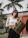 Smiling woman holding a colorful shopping bag with tropical patterns.