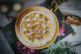 Close-up of a beautifully decorated artisanal cake with floral details on a rustic wooden table.