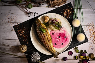 A vibrant plate featuring grilled snapper with tropical sides and a colorful garnish.