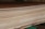 A close-up view of a stack of smooth, evenly cut plywood sheets. The wood grain and layers are visible, indicating high-quality, processed lumber. The sheets are neatly aligned and resting on a green support structure.