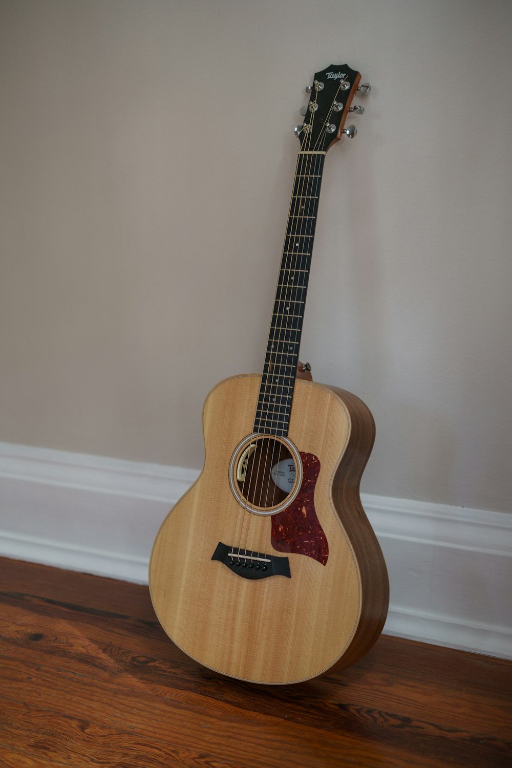 a wooden guitar sitting on top of a hard wood floor