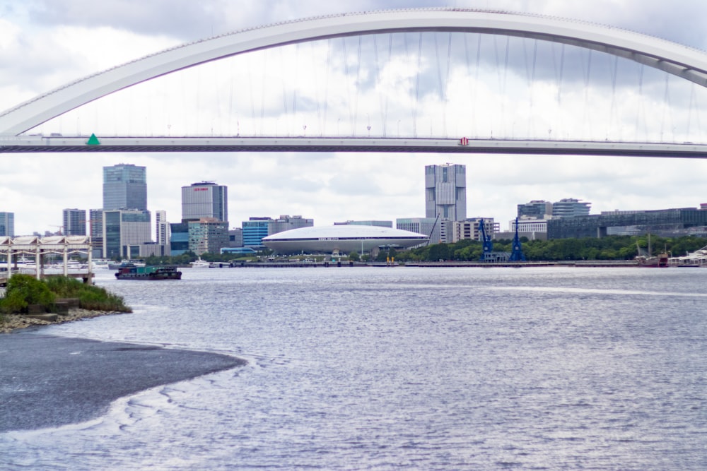 a bridge over a body of water with a city in the background