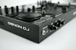 Denon DJ controller showcased on a wooden DJ booth with headphones