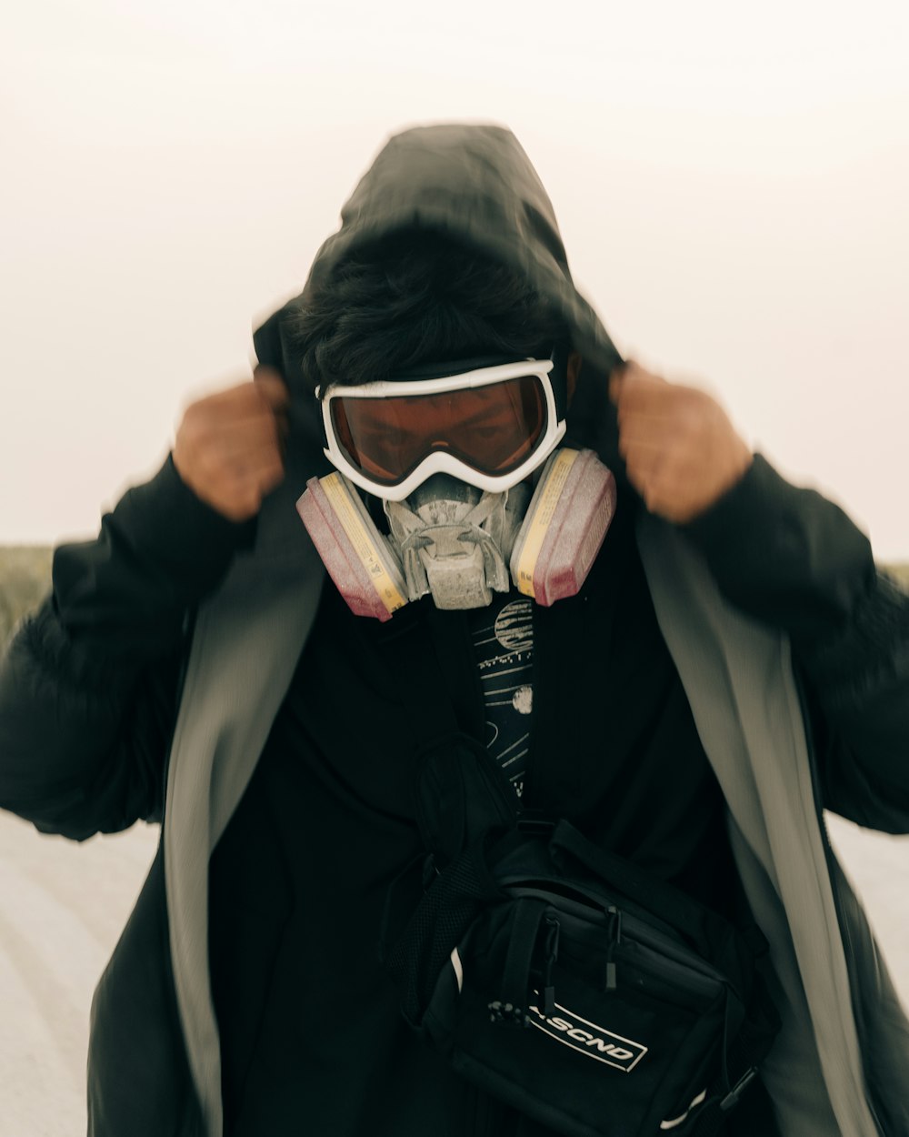 a person wearing a coat and goggles with a backpack
