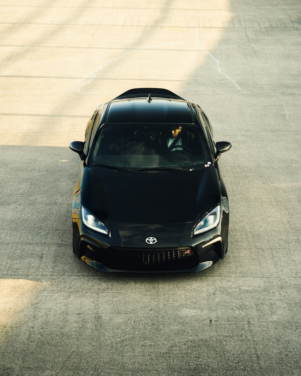 a black sports car driving down a road