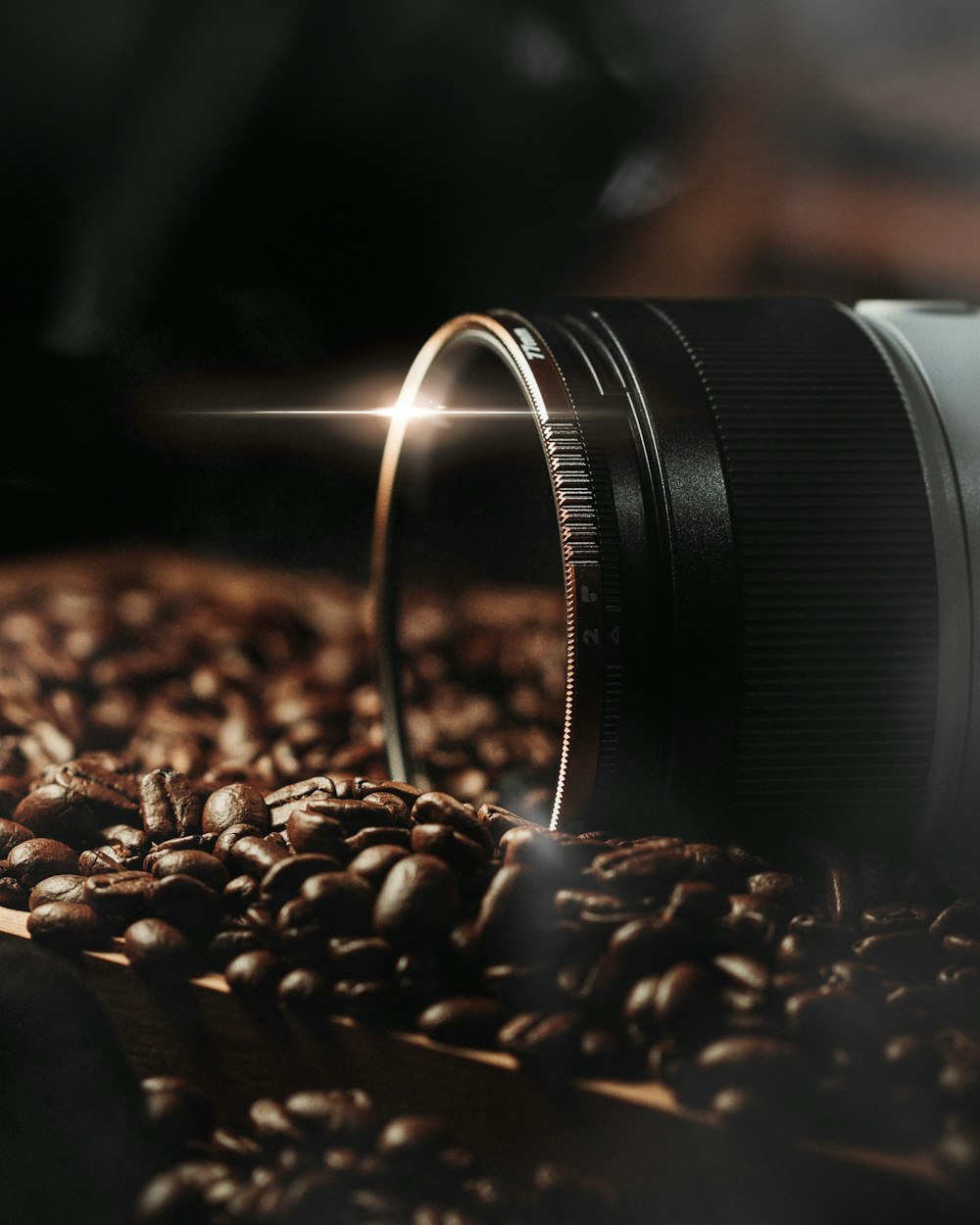 a camera lens sitting on top of a pile of coffee beans