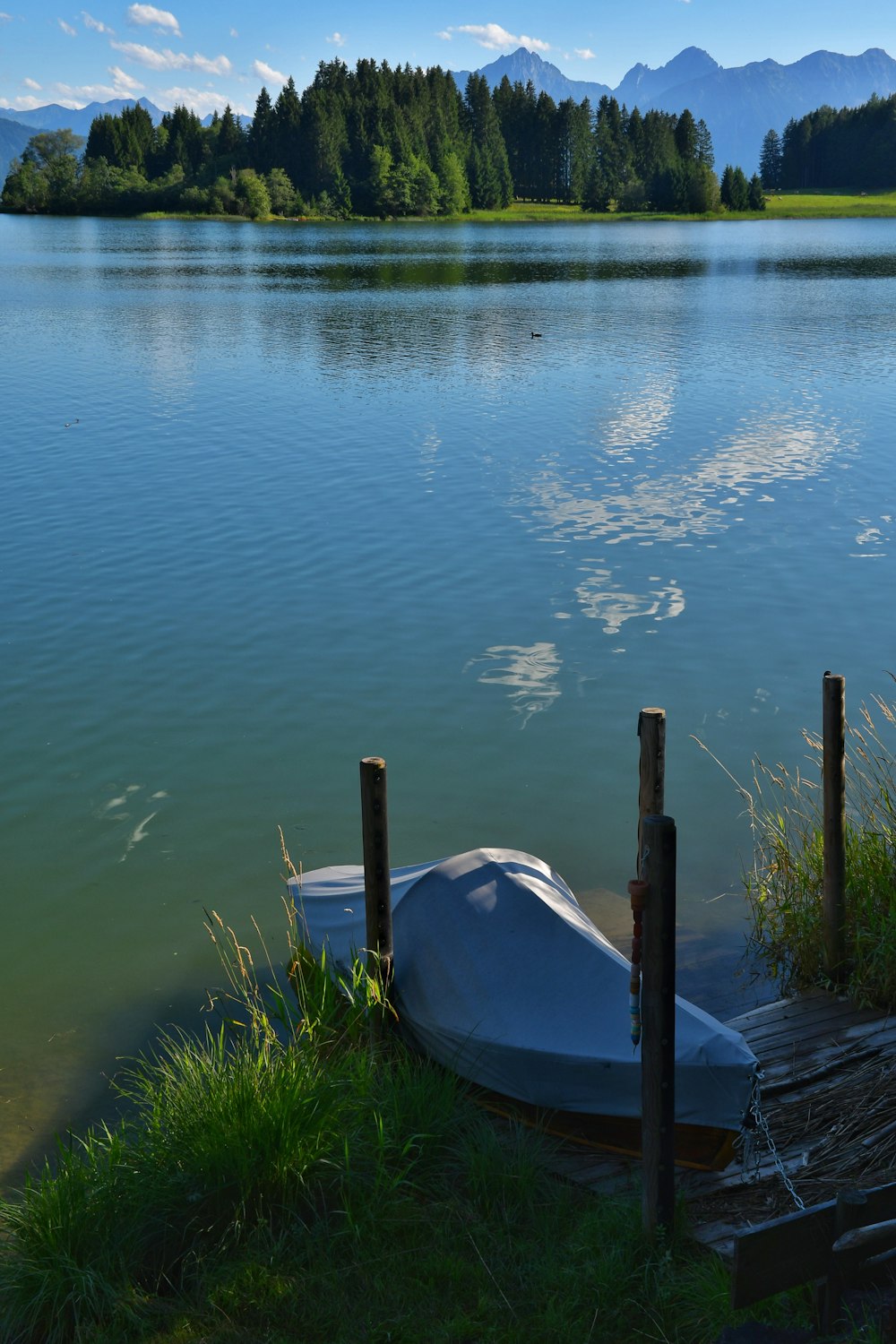 a boat tied up to a dock on a lake