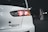A close-up view of the rear section of a white car, highlighting the tail light. The car is in a dimly lit parking garage. The badge on the back of the car reads 'Evolution Final Edition.'