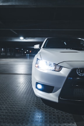 Modern car headlights glowing softly in a dim garage