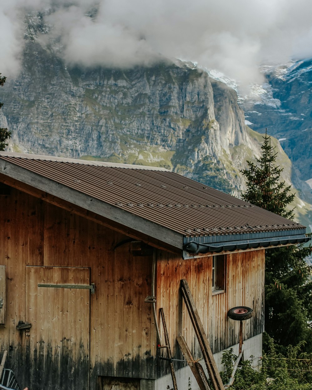 a wooden building with a mountain in the background