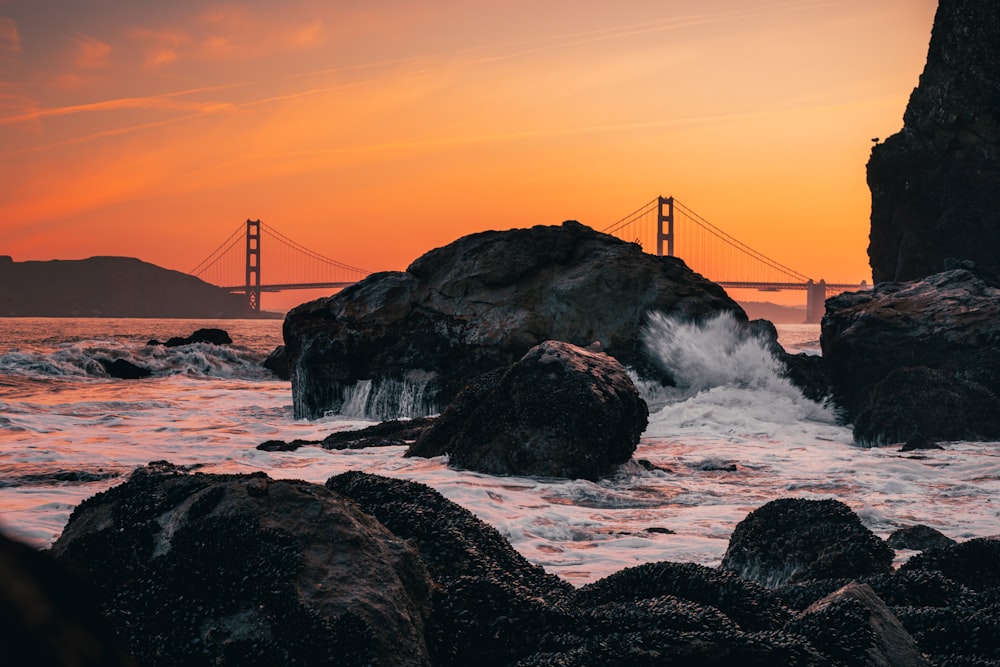 the golden gate bridge in the distance as the sun sets