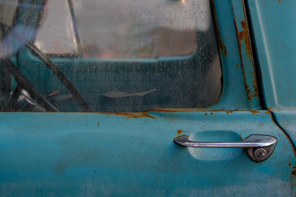 an old blue truck with a door handle