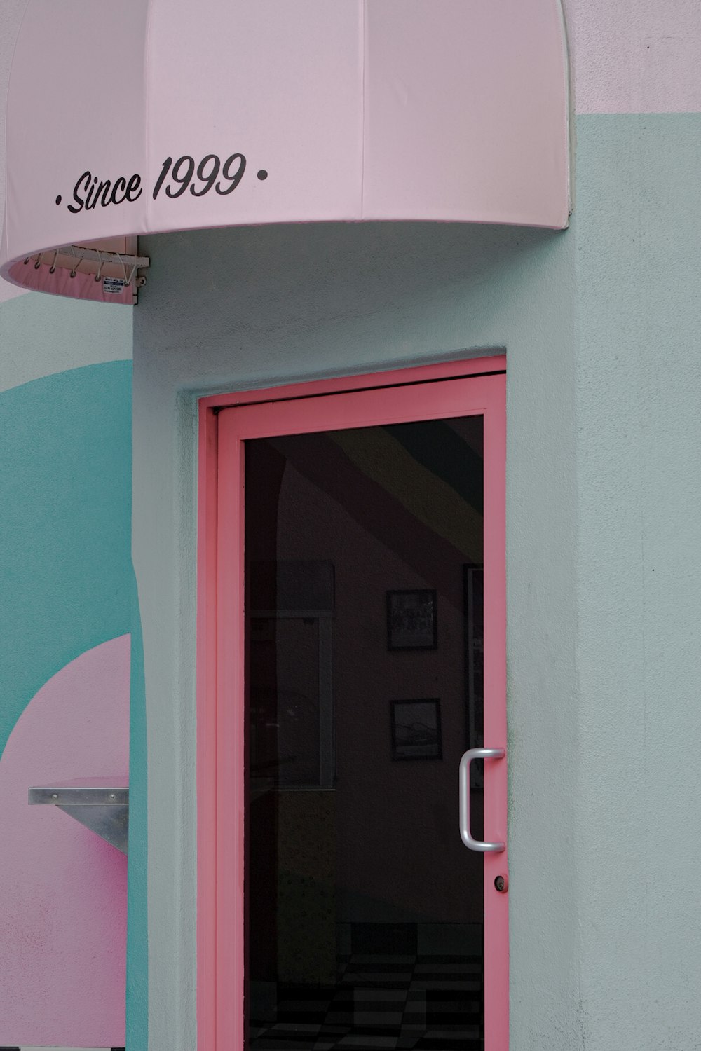 a pink door with a surfboard on top of it