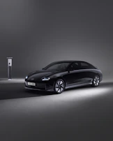 A sleek hybrid car being carefully serviced by a technician with modern tools.