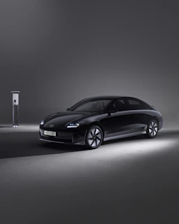 Sleek electric car charging at a modern, minimalistic station under soft LED lights