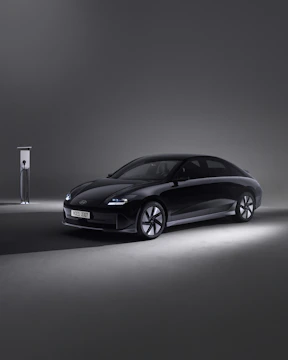 Sleek electric vehicle charging at dusk with neon green light accents.