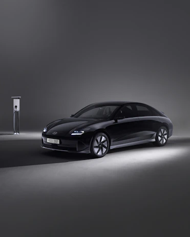 Modern electric vehicle with a sleek black finish displayed in a minimalist garage
