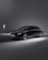 A sleek, modern black car is parked beside an EV charging station in a minimalistic setting. The environment is dimly lit, with the car illuminated by soft spotlights, creating an elegant and futuristic atmosphere.