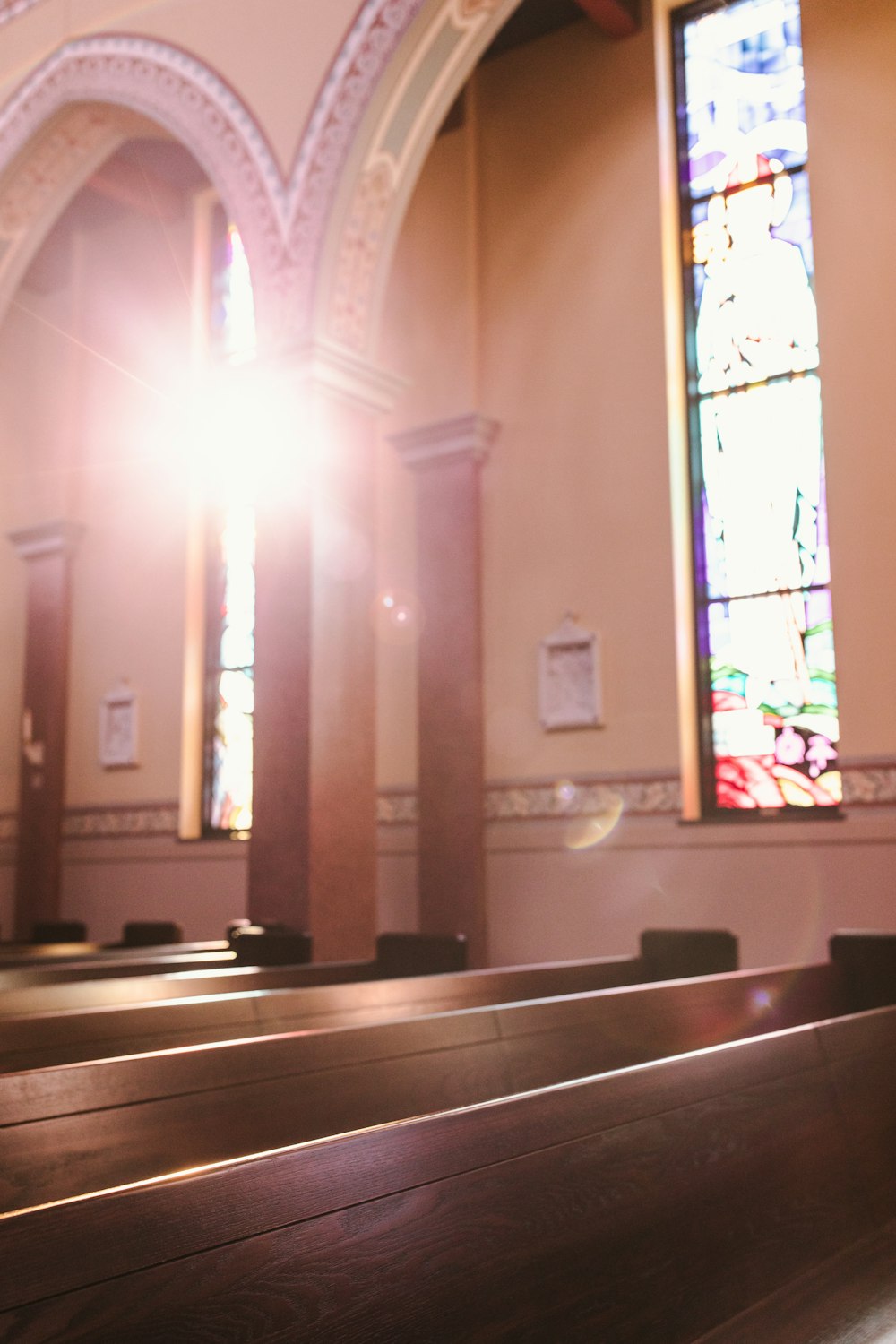 sunlight shining through a stained glass window in a church