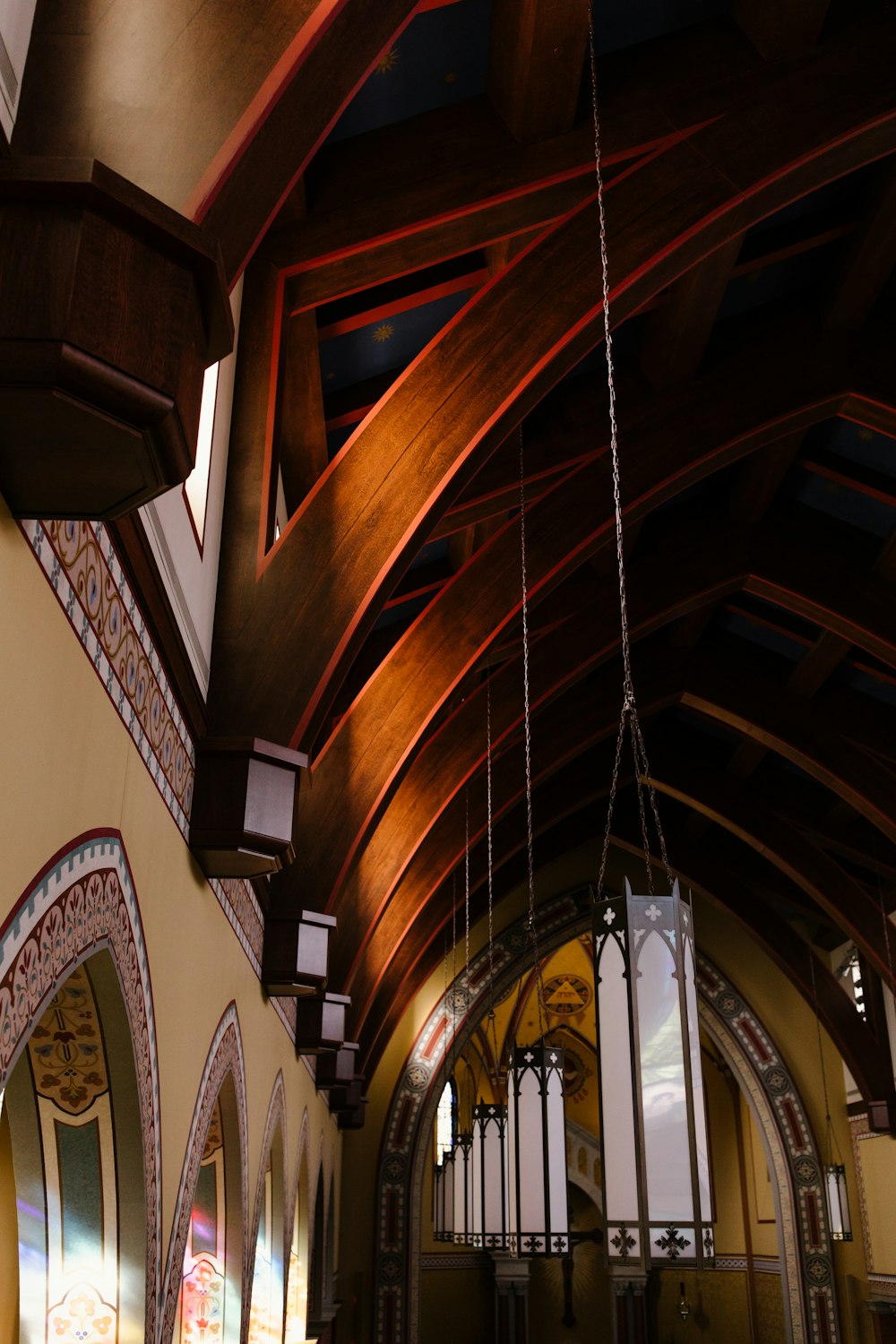 a church with a wooden ceiling and stained glass windows