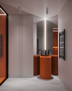 a modern bathroom with orange and white fixtures