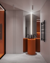 a modern bathroom with orange and white fixtures