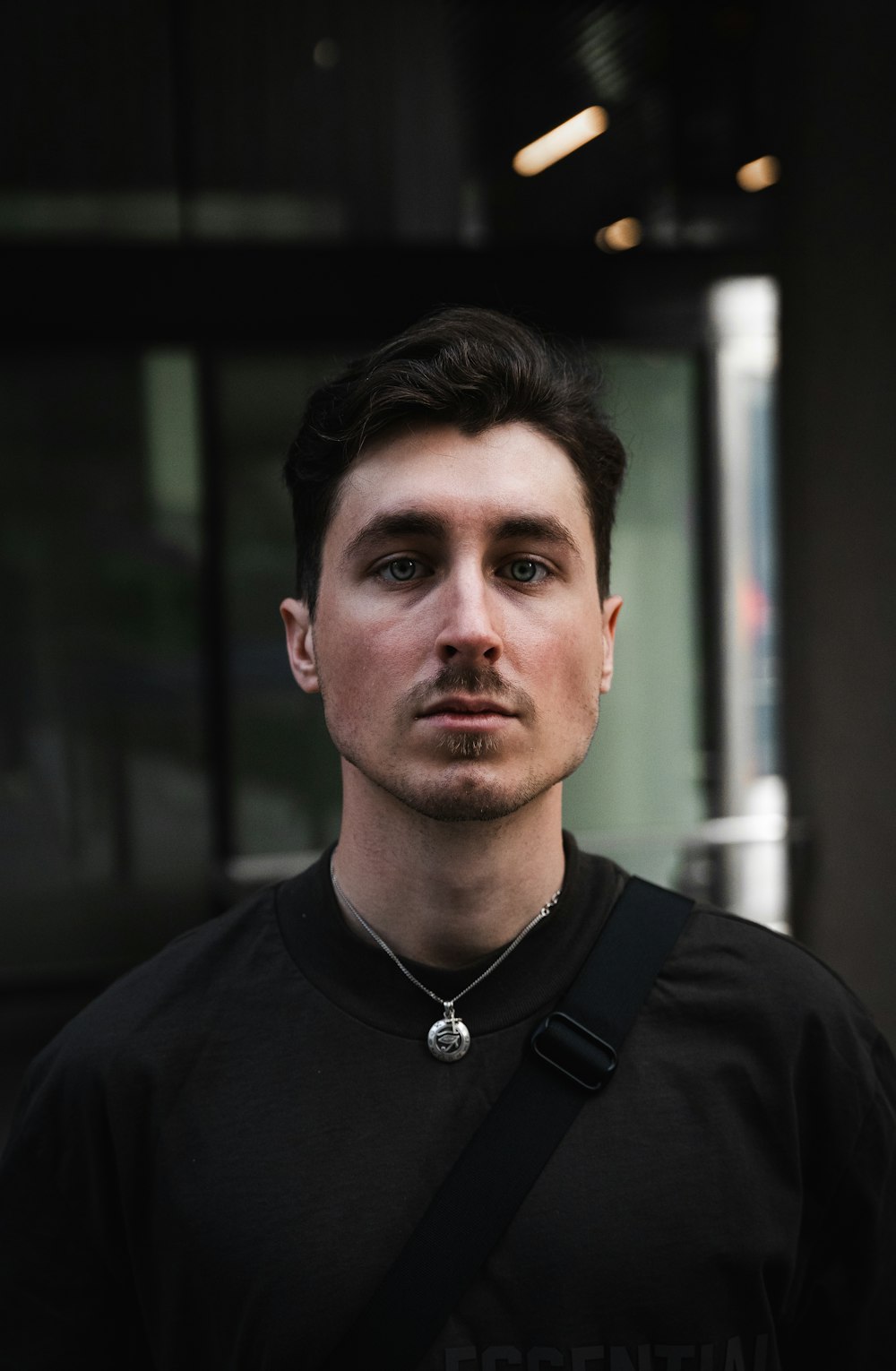 a man wearing a black shirt and a cross necklace