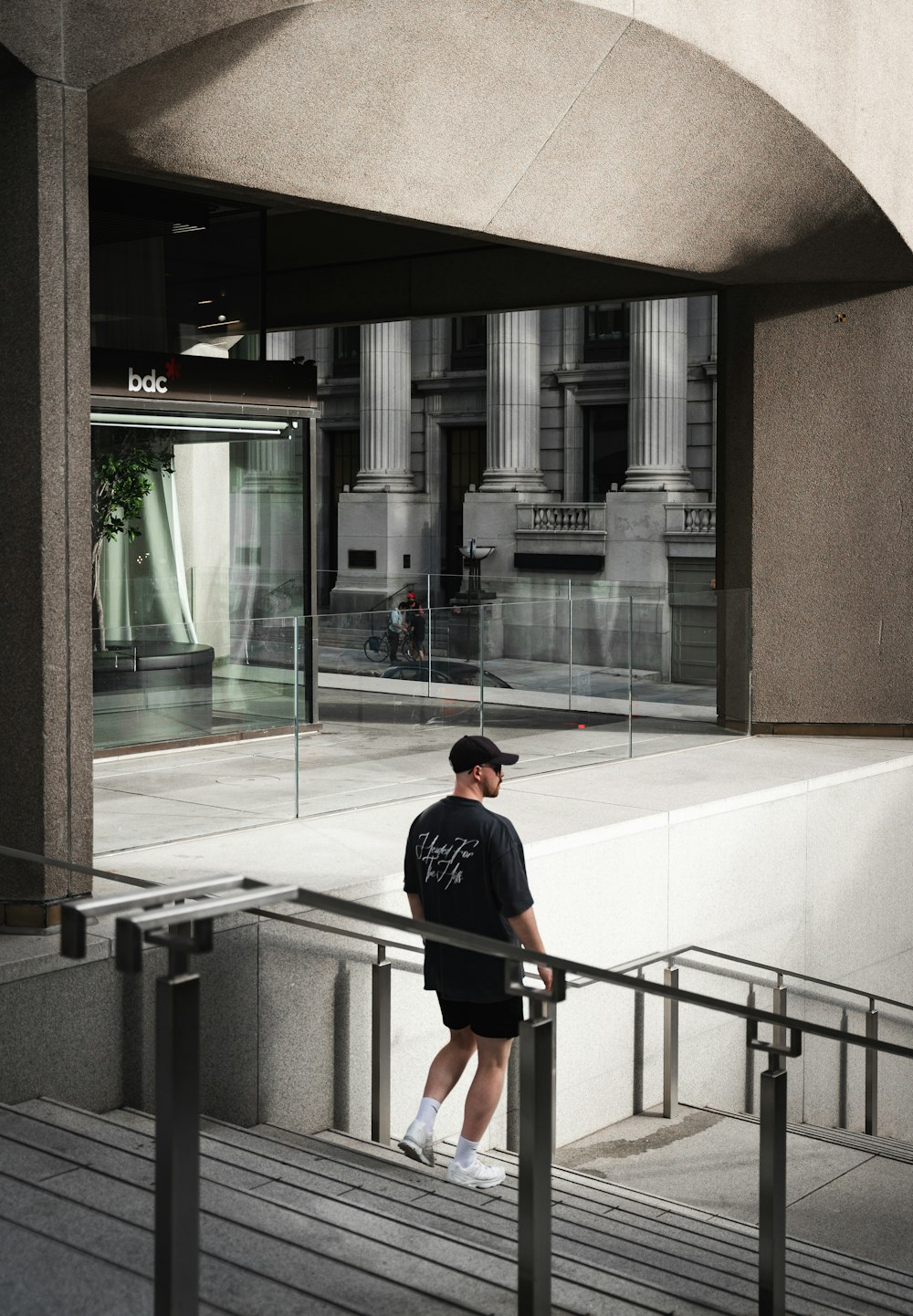 a man is standing on a railing in front of a building