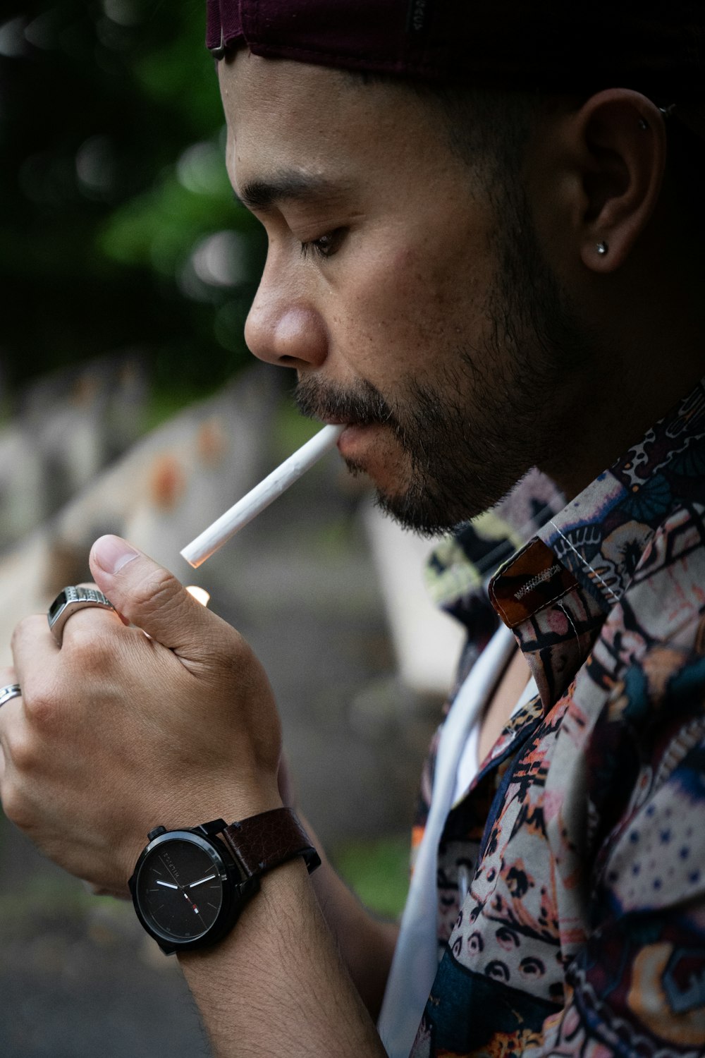 a man with a watch on his wrist smoking a cigarette