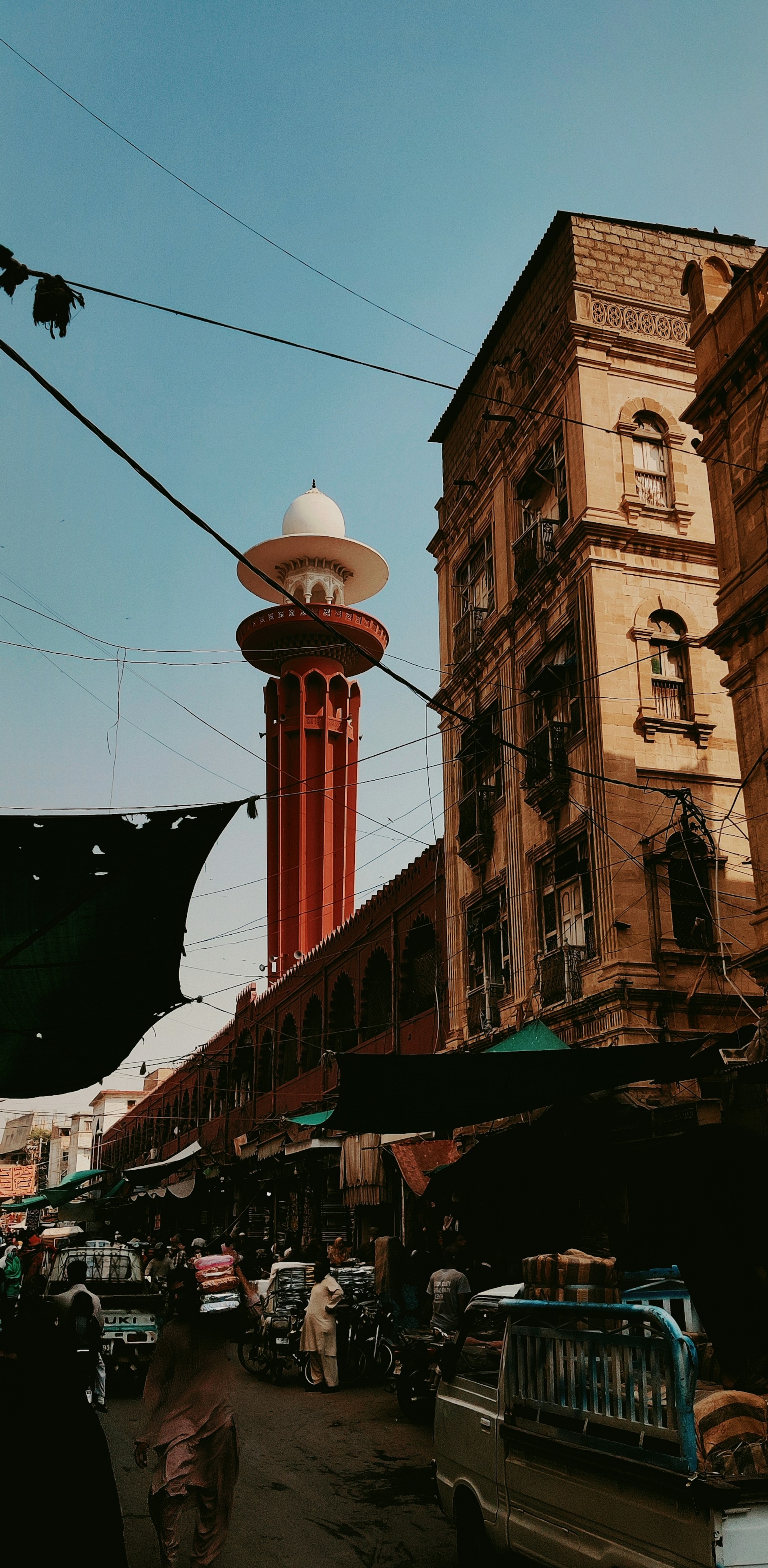 A bustling street scene in Istanbul, showcasing colorful markets and the silhouette of the Hagia Sophia at dusk.