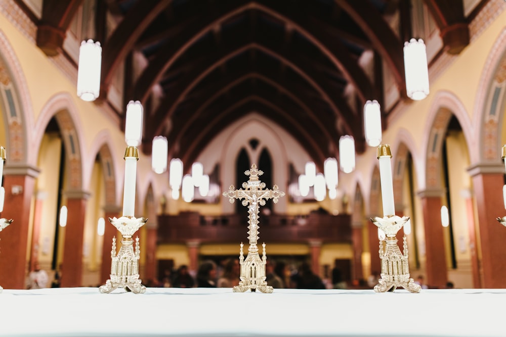a white table topped with a cross and candles