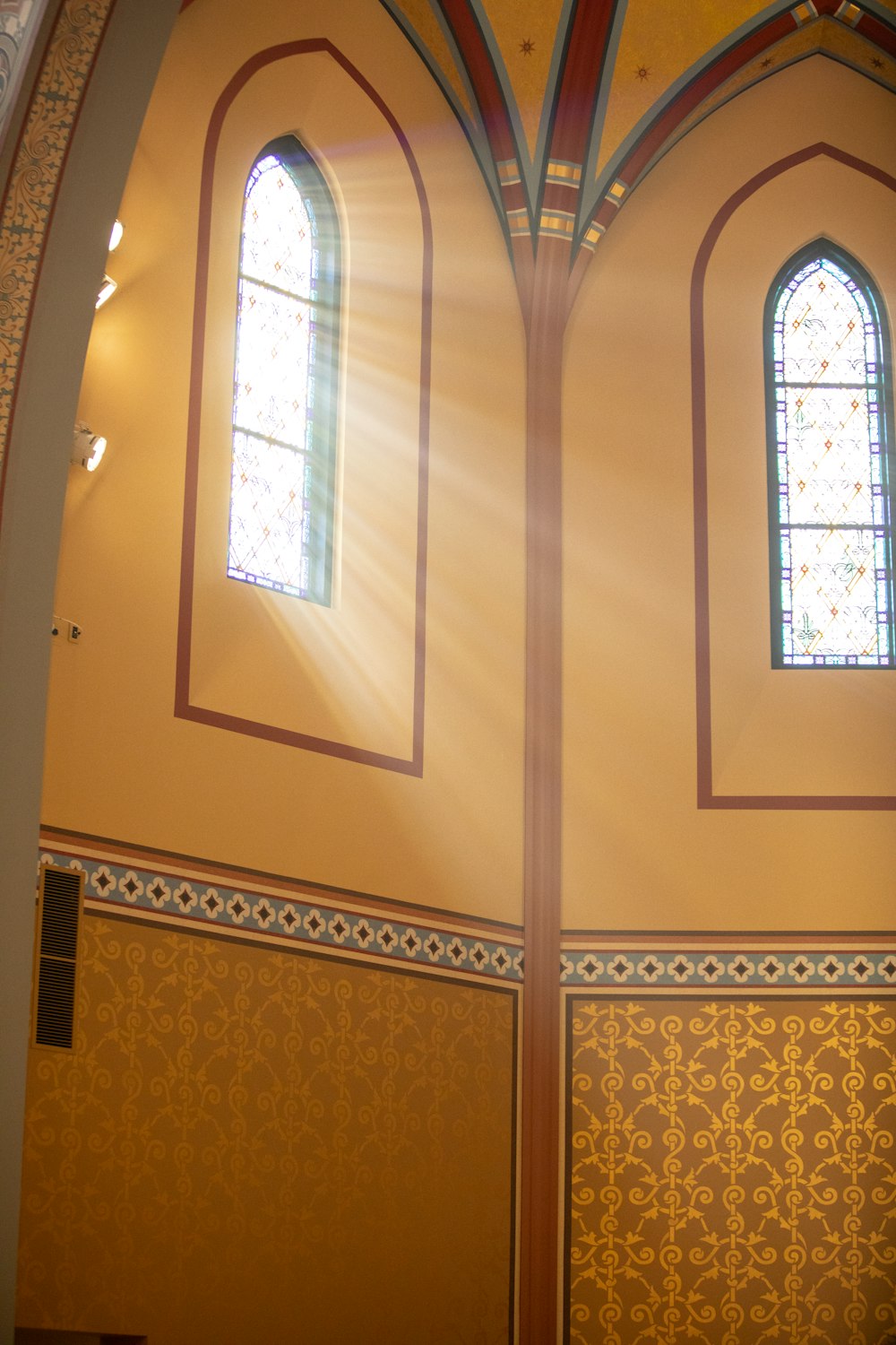 sunlight shining through the stained glass windows of a church