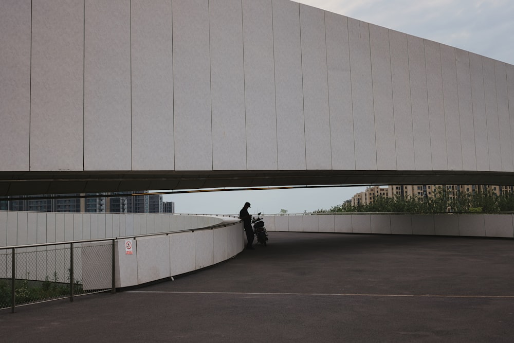 a person riding a motorcycle under a bridge