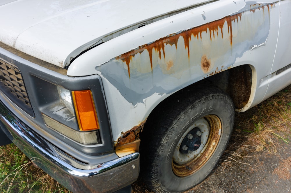 an old white truck with rust on it
