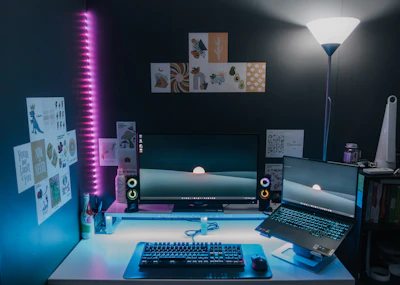 A sleek office desk setup featuring a high-performance laptop and multiple computer accessories bathed in natural light.