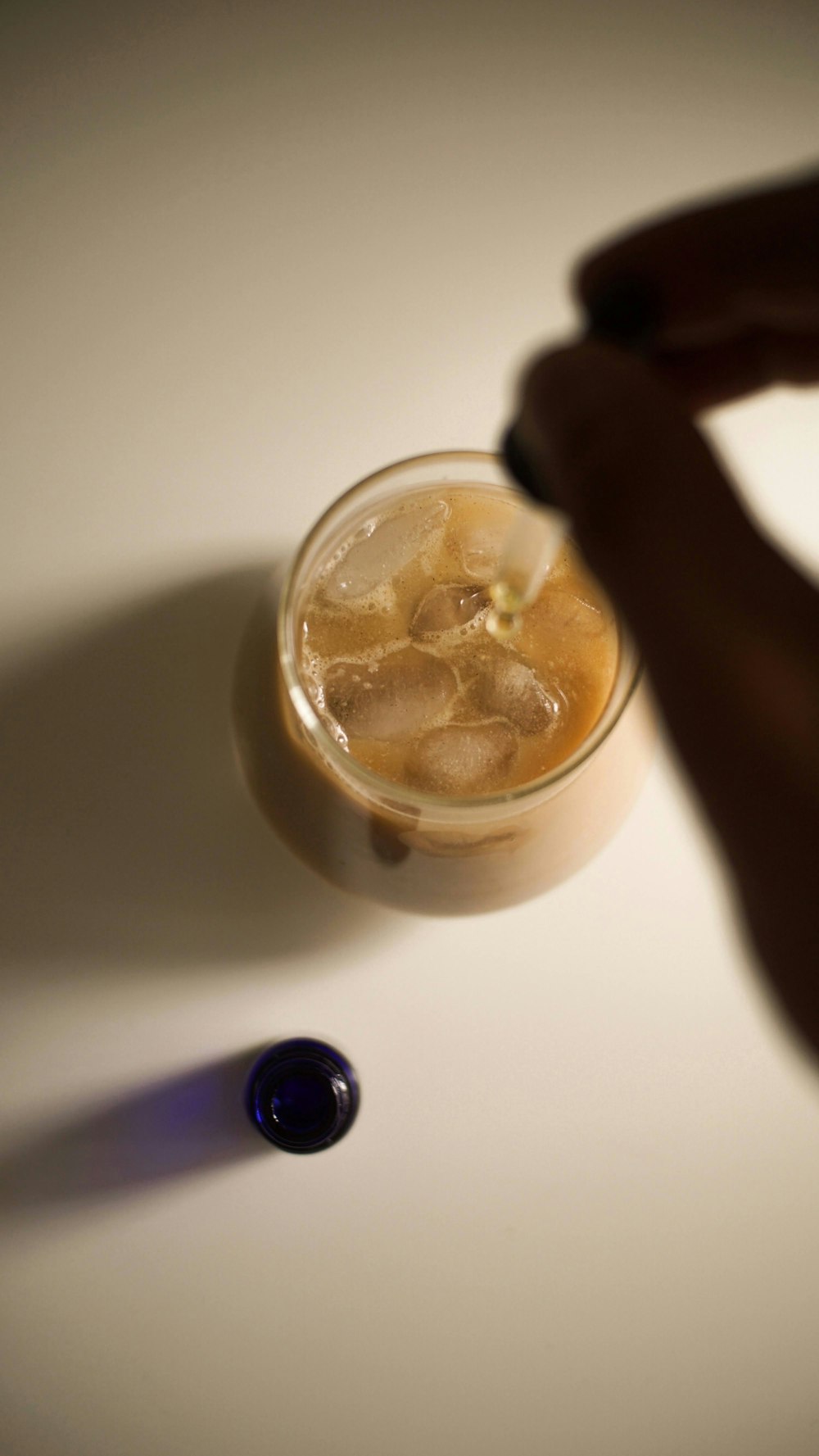 a glass of ice tea with a spoon next to it