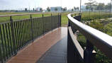 A long wooden-colored PRFV pultruded walkway winding through a green park area