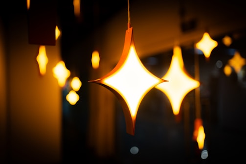 Unique lighting fixtures glowing warmly in a decorated event space.