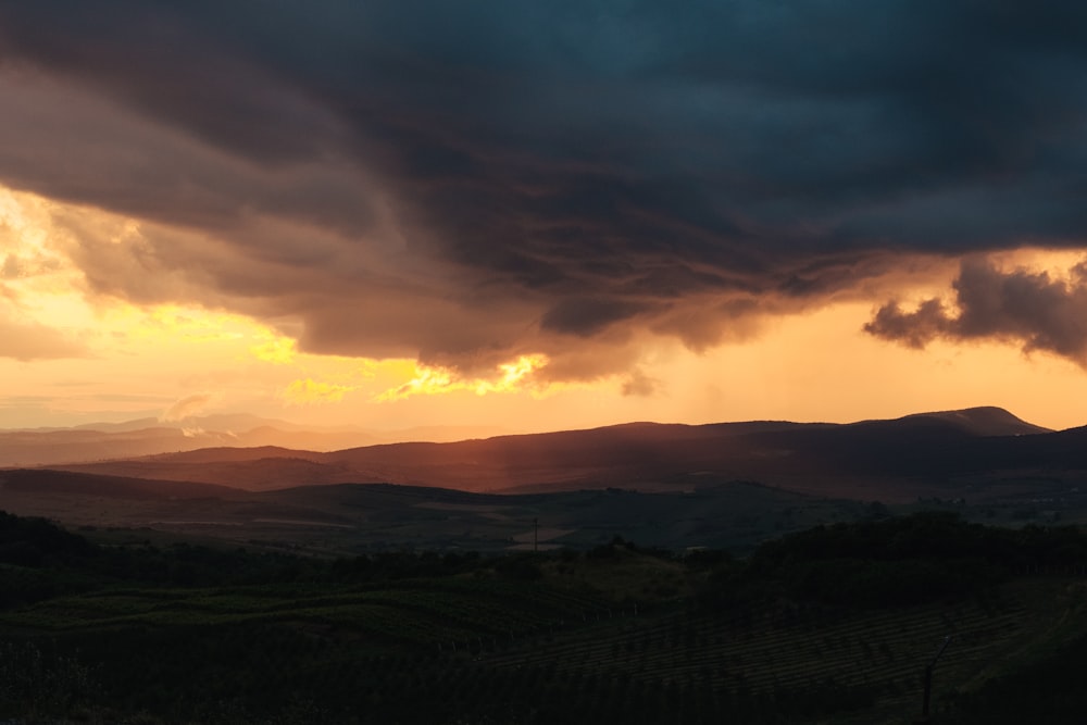 the sun is setting over a mountain range