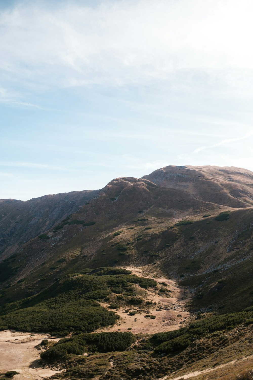 a view of a mountain range from the top of a hill