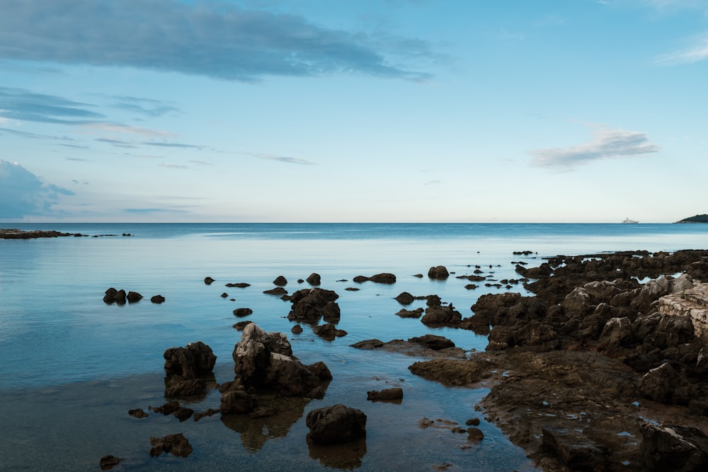 a body of water with rocks in the foreground