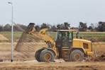 a bulldozer digging dirt in a field