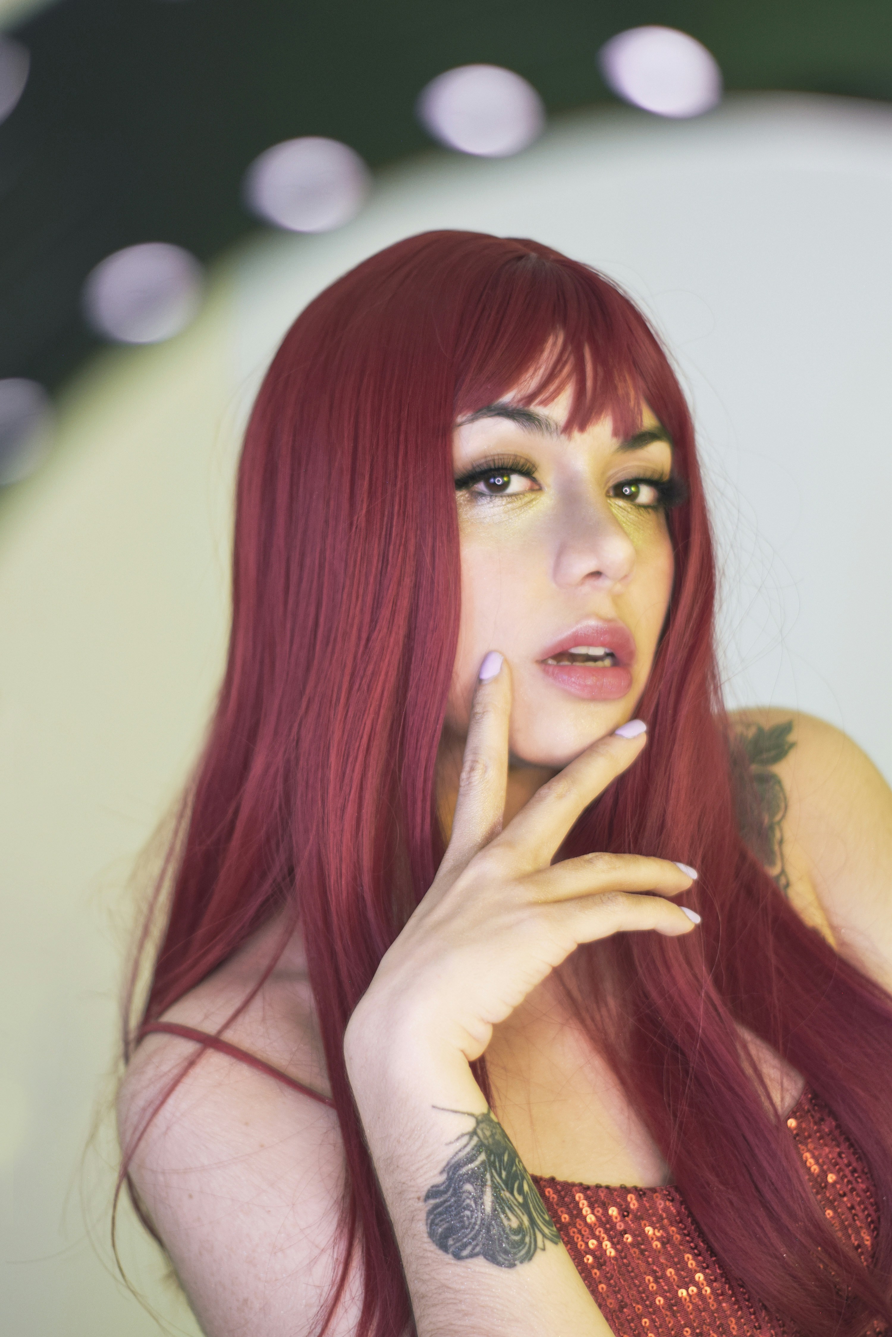 Seorang wanita dengan rambut merah panjang sedang berpose untuk berfoto