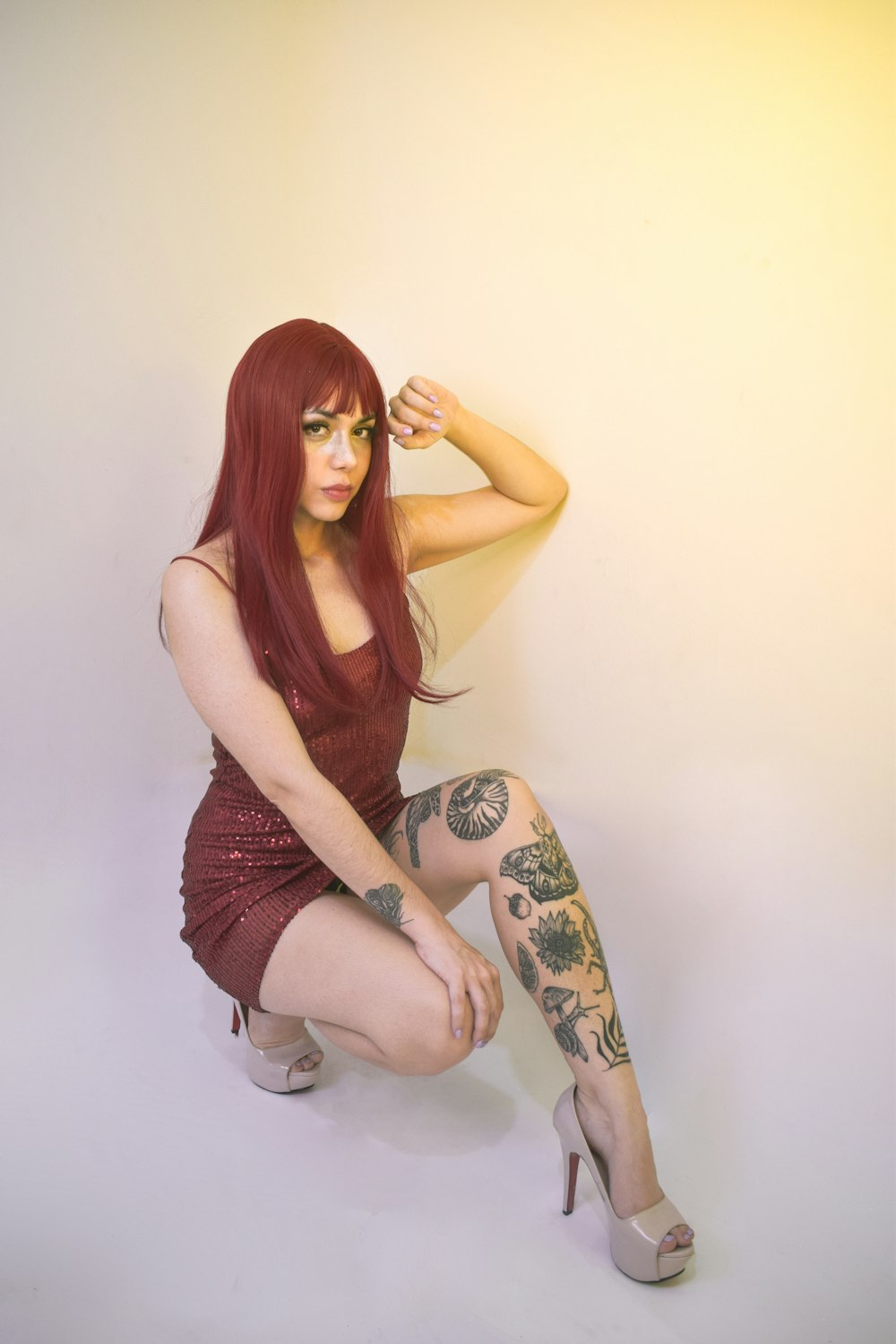 a woman with red hair and tattoos posing for a picture