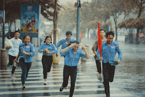 A group of friends in Lumina outfits laughing and crossing a busy city intersection.