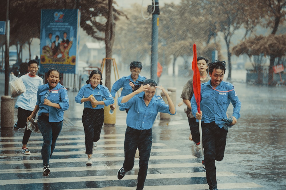 a group of people crossing a street in the rain